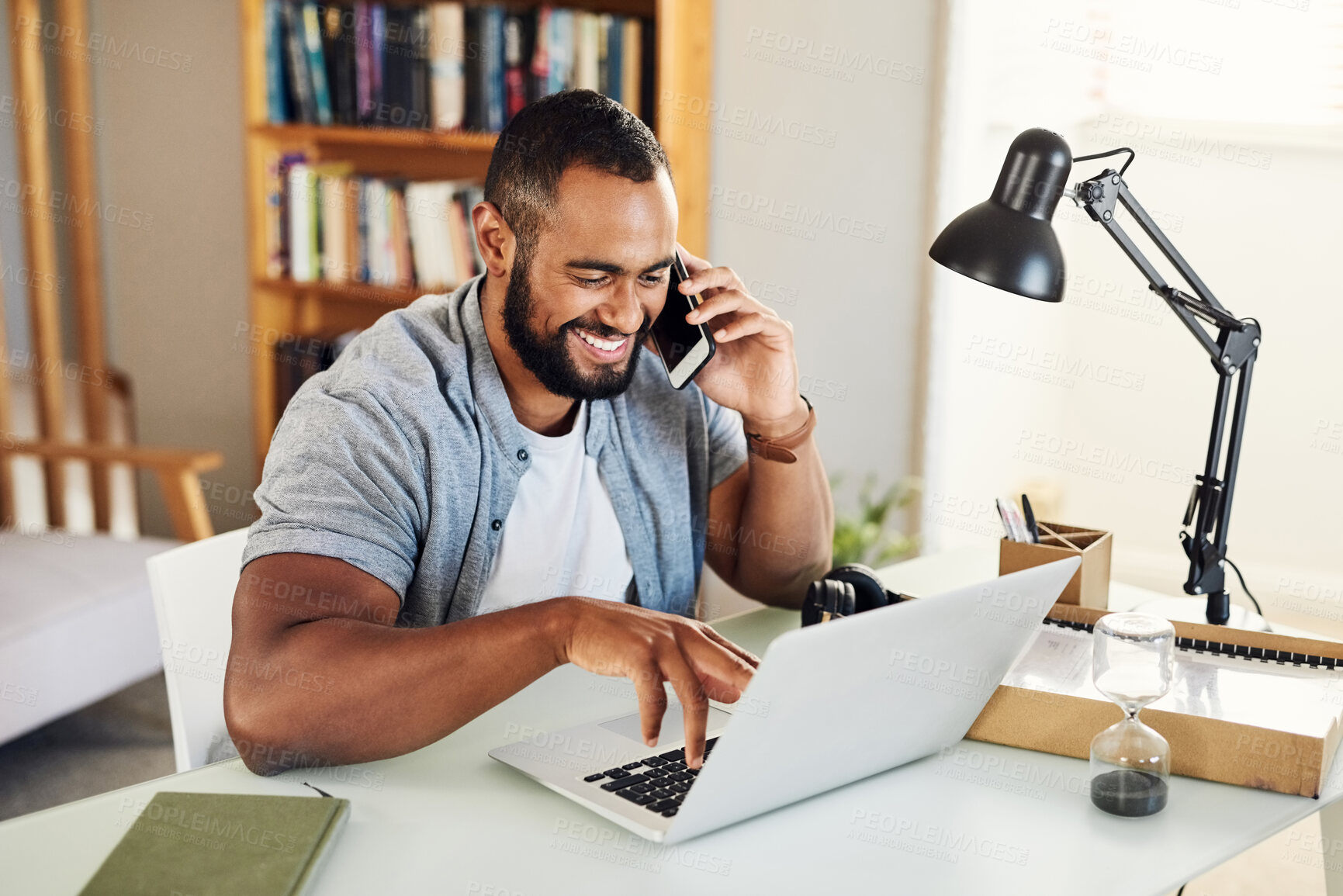 Buy stock photo Shot of a handsome businessman using his smartphone to make a phonecall while working from home