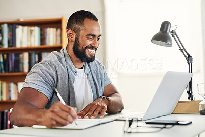 Buy stock photo Shot of a young male businessman working from home and writing in his notebook