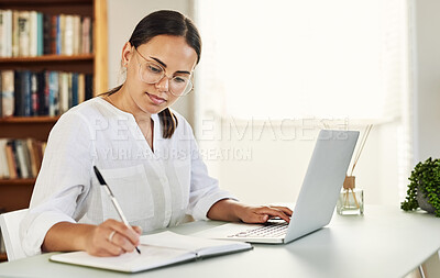 Buy stock photo Shot of a young businesswoman writing in her diary while working from home