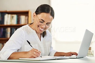 Buy stock photo Shot of a young businesswoman writing in her diary while working from home