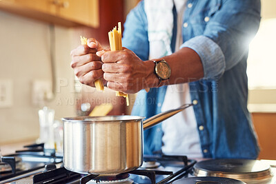 Buy stock photo Shot of a man breaking spaghetti before boiling it