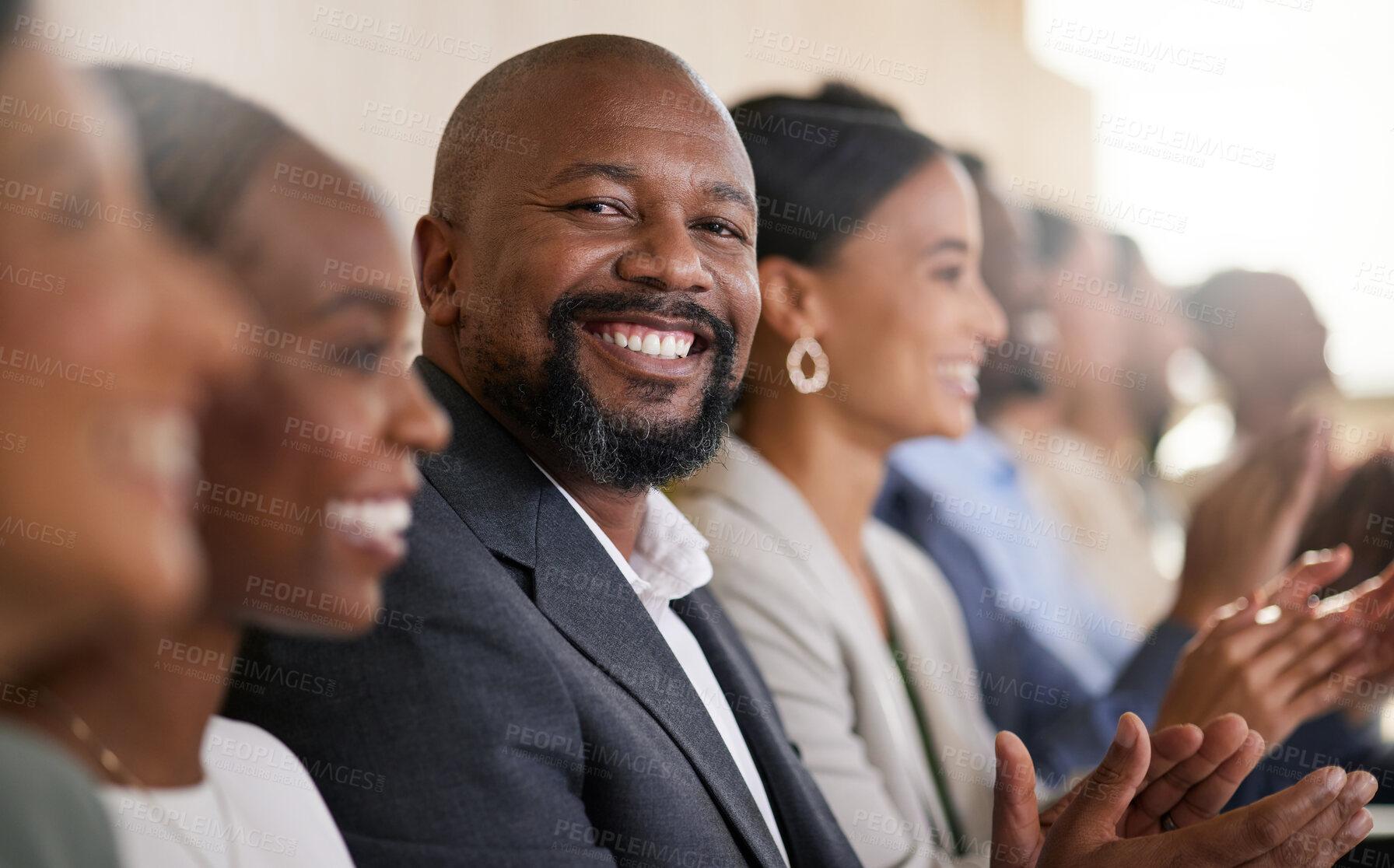 Buy stock photo Cropped portrait of a handsome mature businessman applauding while sitting with his colleagues in the boardroom during a presentation