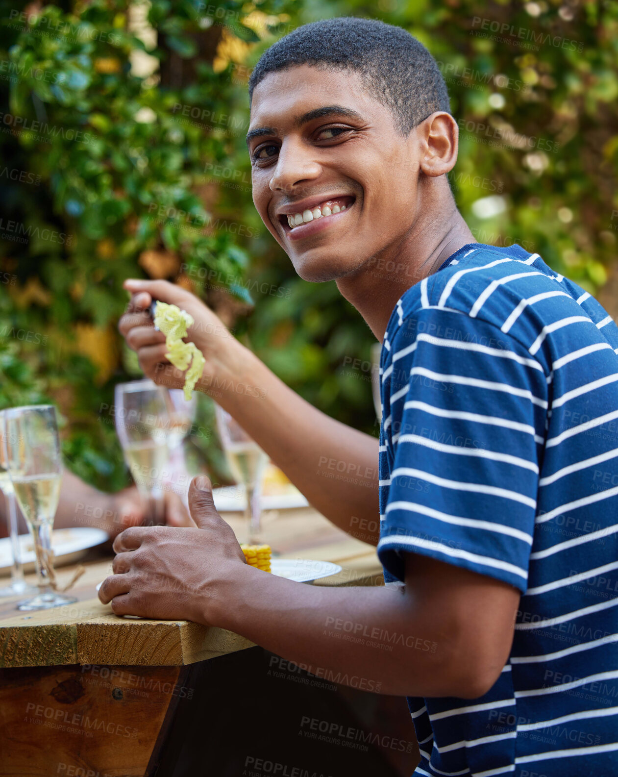Buy stock photo Shot of a young man enjoying lunch with his friends in a outdoor cafe