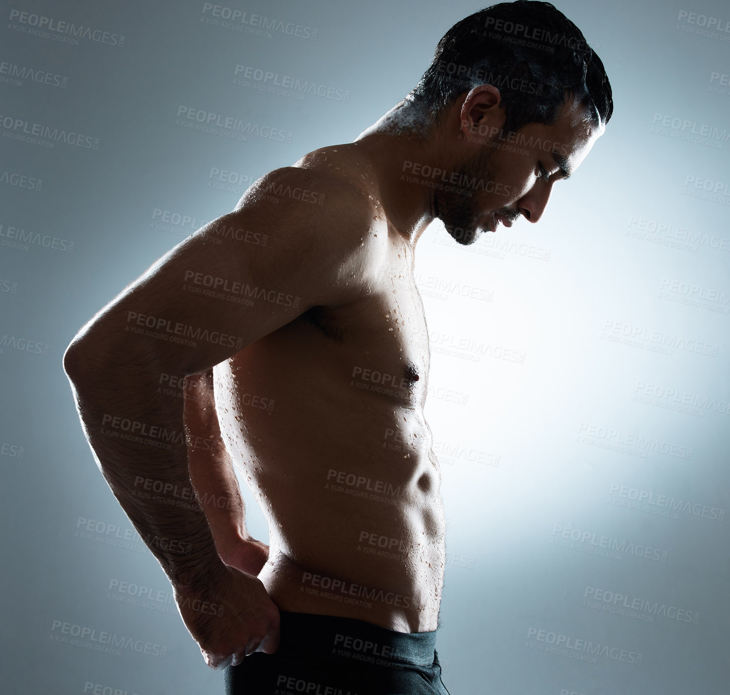 Buy stock photo Studio shot of a young man washing his hair in a shower against a grey background