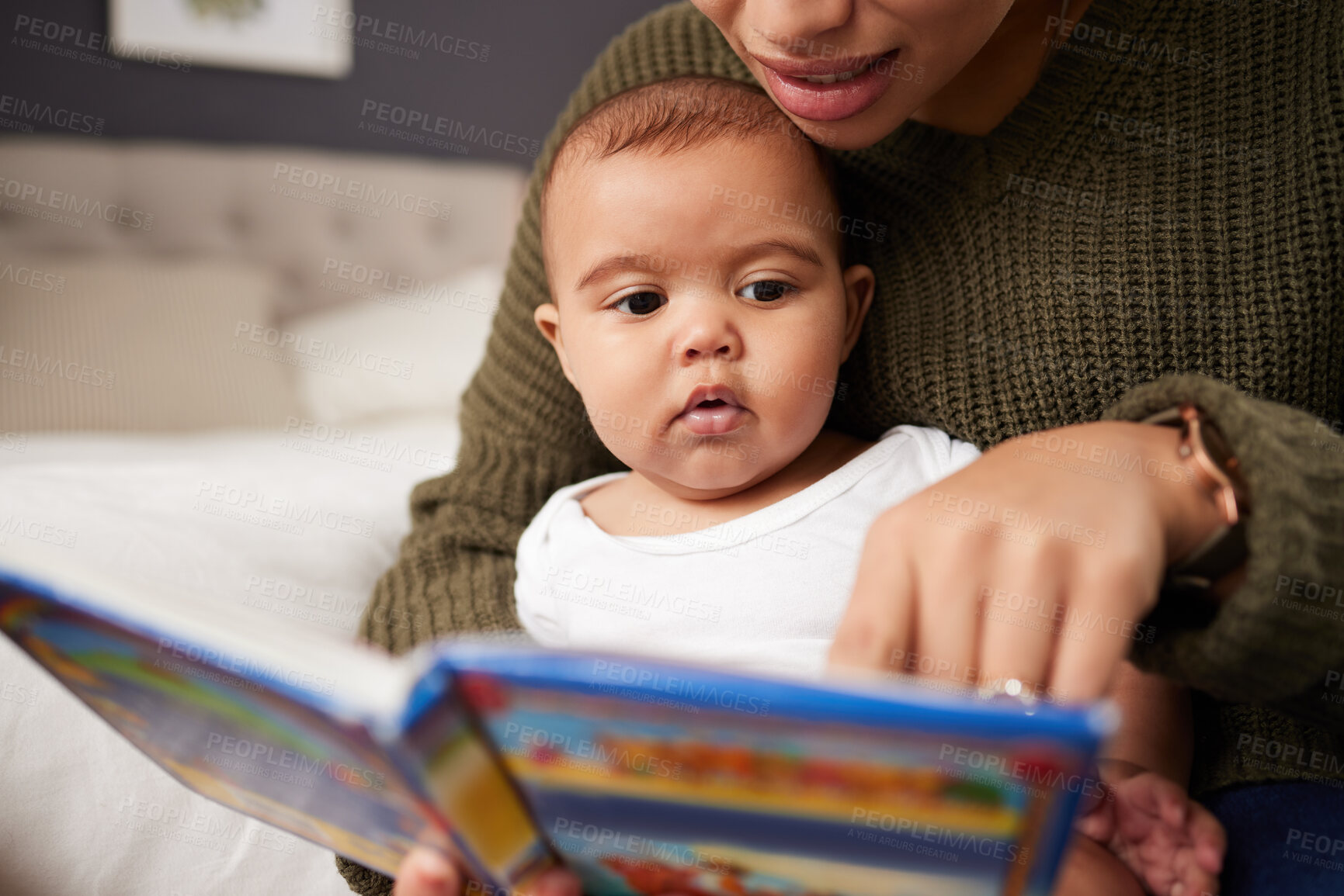 Buy stock photo Shot a mother reading a book to her baby at home