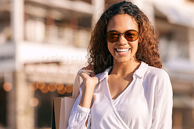 Buy stock photo Shot of an attractive young woman standing alone outside while shopping in the city