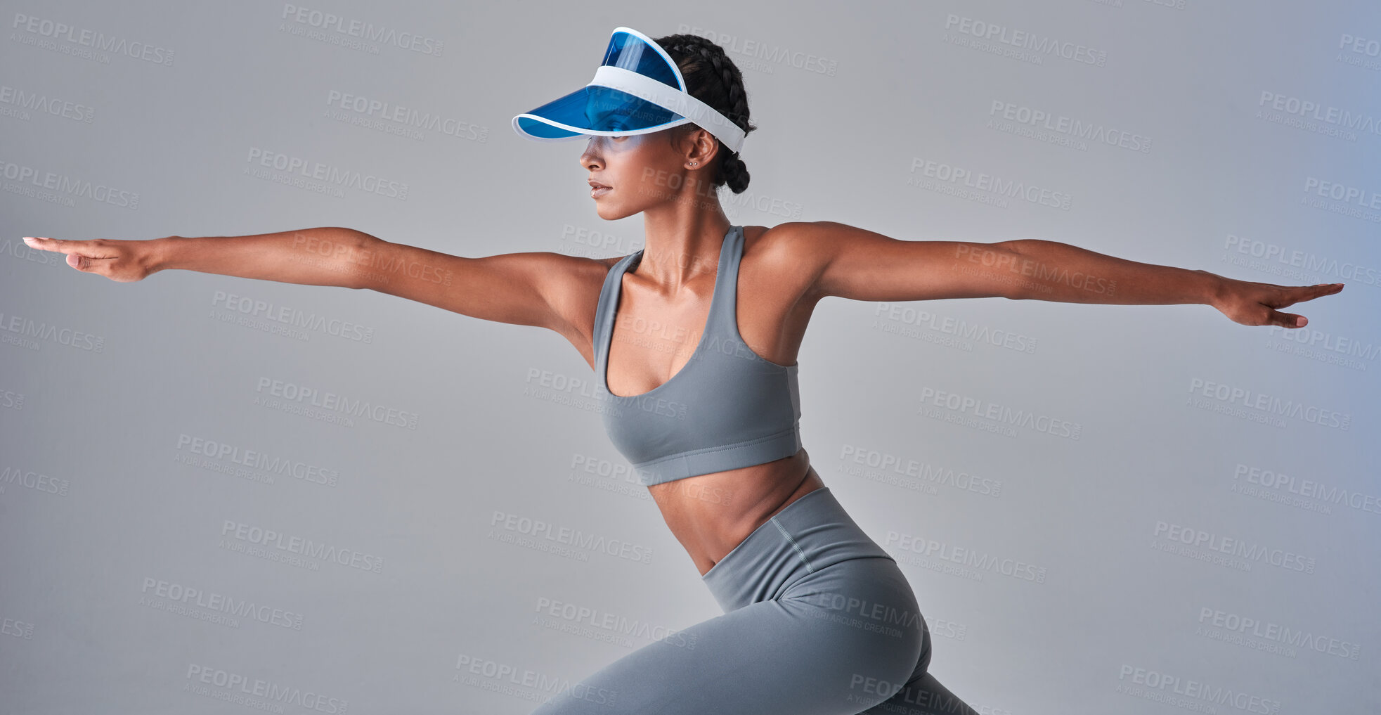 Buy stock photo Studio shot of a fit young woman stretching against a grey background