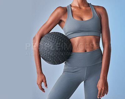 Buy stock photo Studio shot of a fit woman working out with a medicine ball against a grey background