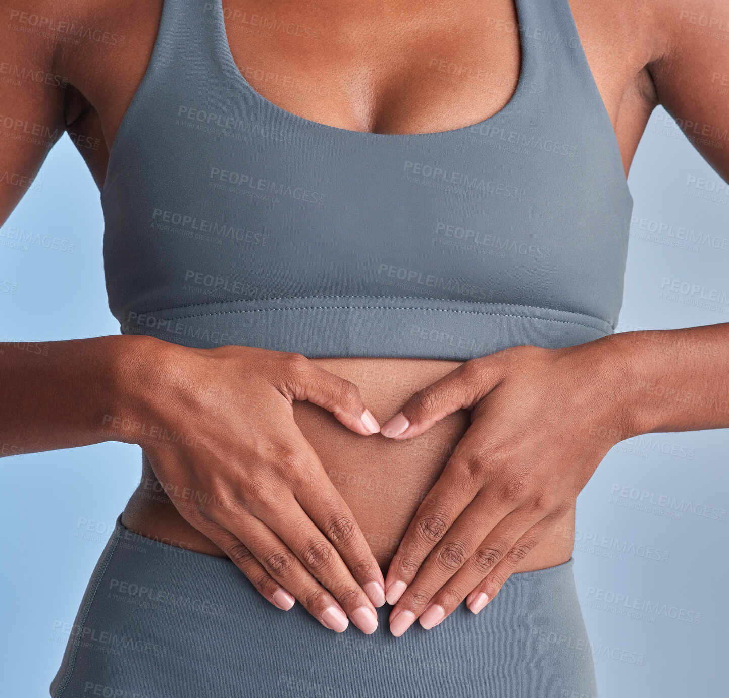 Buy stock photo Fitness, stomach and woman in studio with heart hands, gut health and inspiration for body goals. Wellness, belly and athlete with emoji, weight loss and digestion support on gray background.