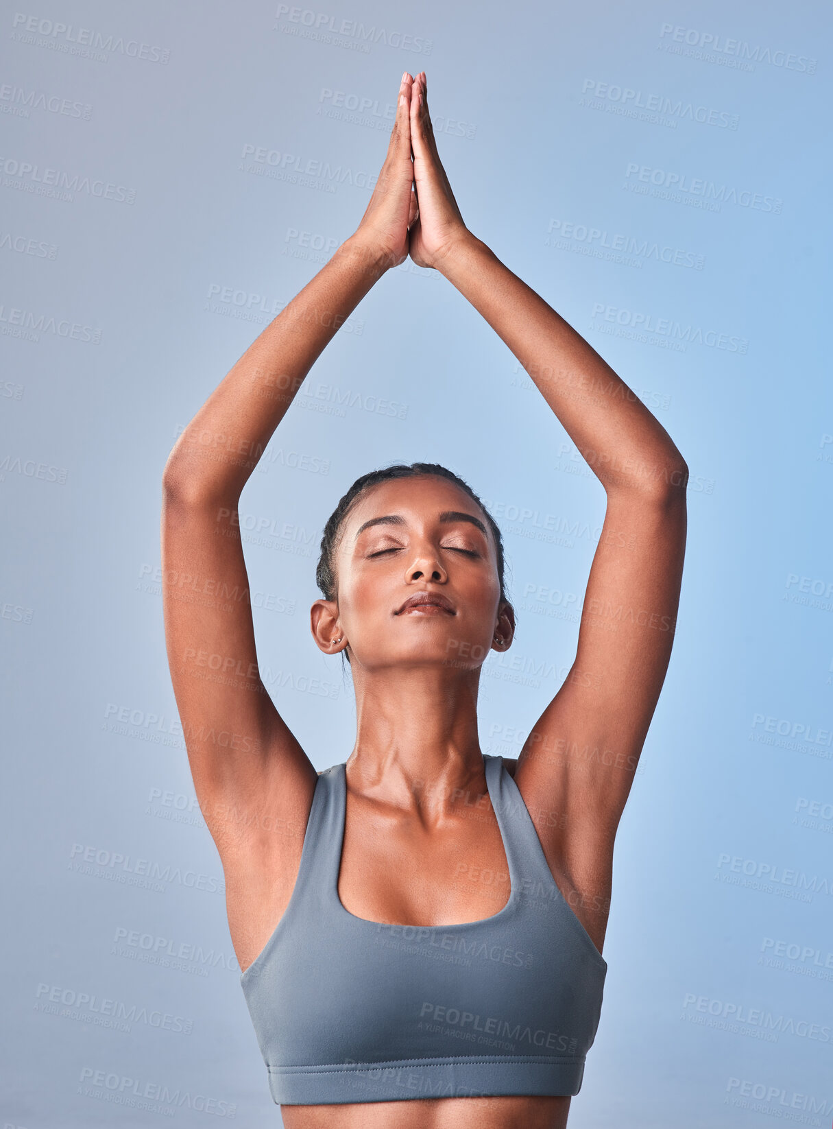 Buy stock photo Studio shot of a fit young woman meditating against a grey background