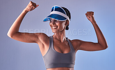 Buy stock photo Studio shot of a fit young woman flexing her muscles against a grey background