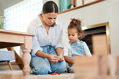Buy stock photo Shot of a mother and her little daughter playing with toys together at home
