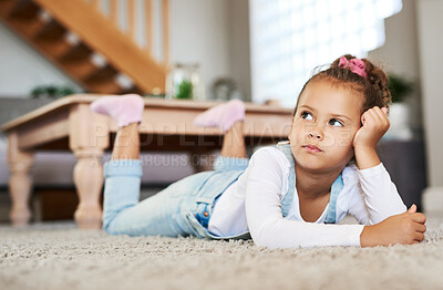 Buy stock photo Shot of an adorable little girl lying on the floor at home