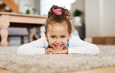 Buy stock photo Portrait of an adorable little girl lying on the floor at home