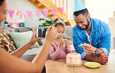 Buy stock photo Shot of a young mother taking a photo at her daughter's birthday celebration at home