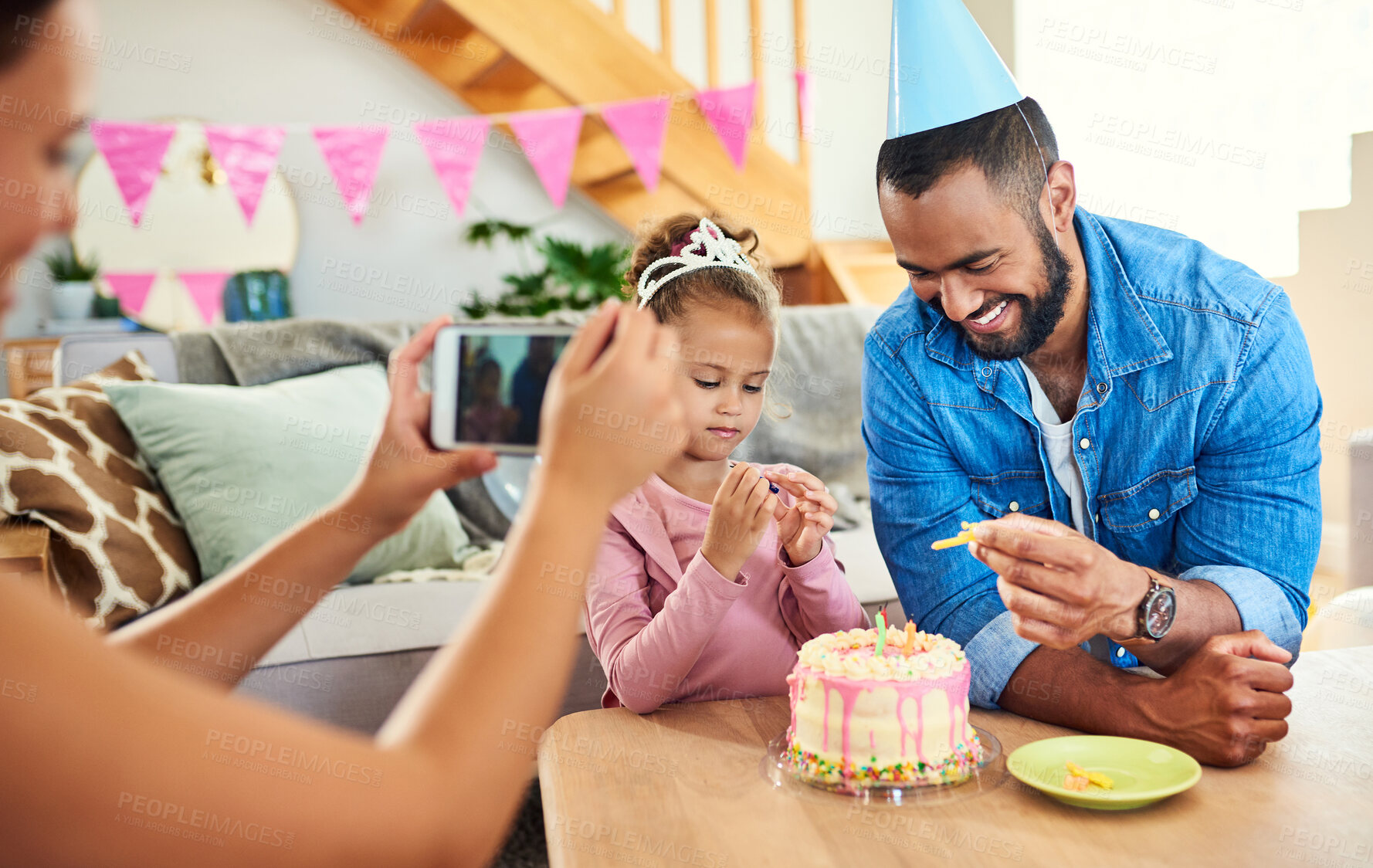 Buy stock photo Shot of a young mother taking a photo at her daughter's birthday celebration at home