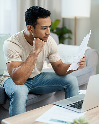 Buy stock photo Serious man, documents and thinking in finance, debt or stress for decision on living room sofa at home. Male person with paperwork in thought or choice for financial plan, expenses or bills at house