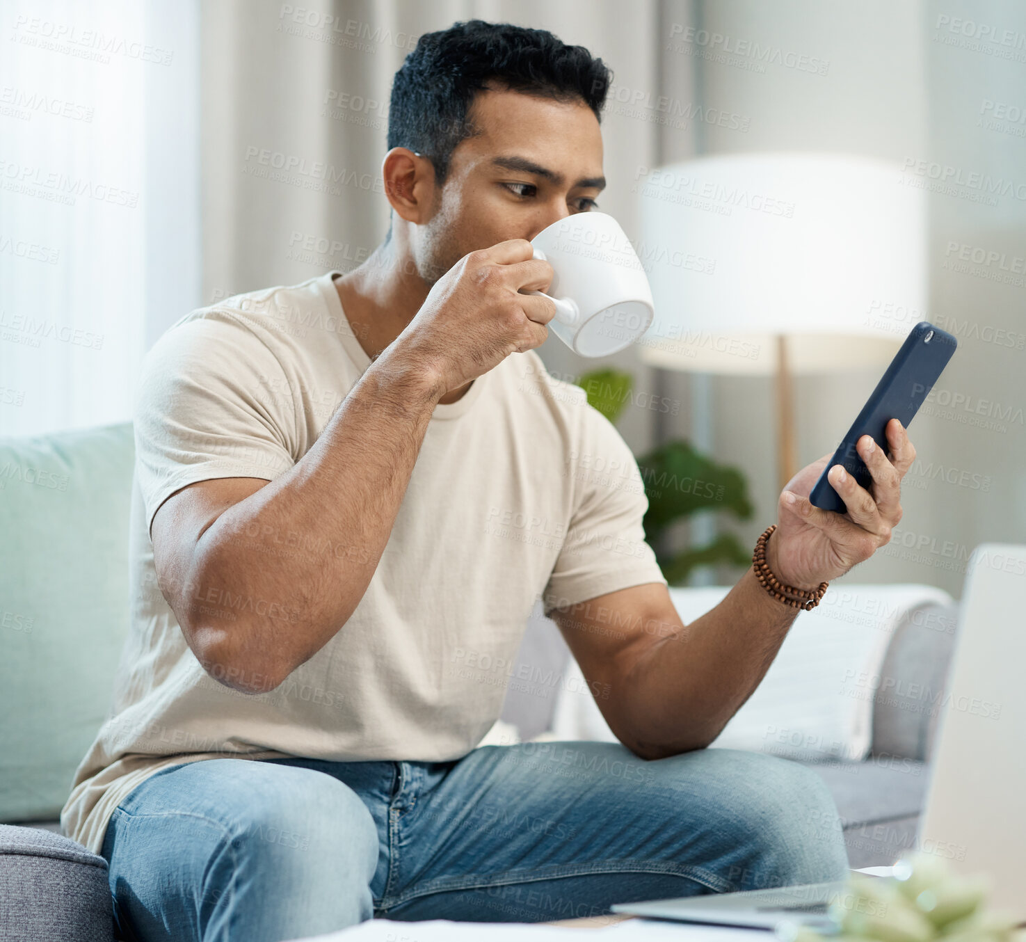 Buy stock photo Man, phone and reading with coffee on sofa in home for taste of hot beverage. Asian person, technology and mobile app for message, internet or social media by cellular with drink to relax living room
