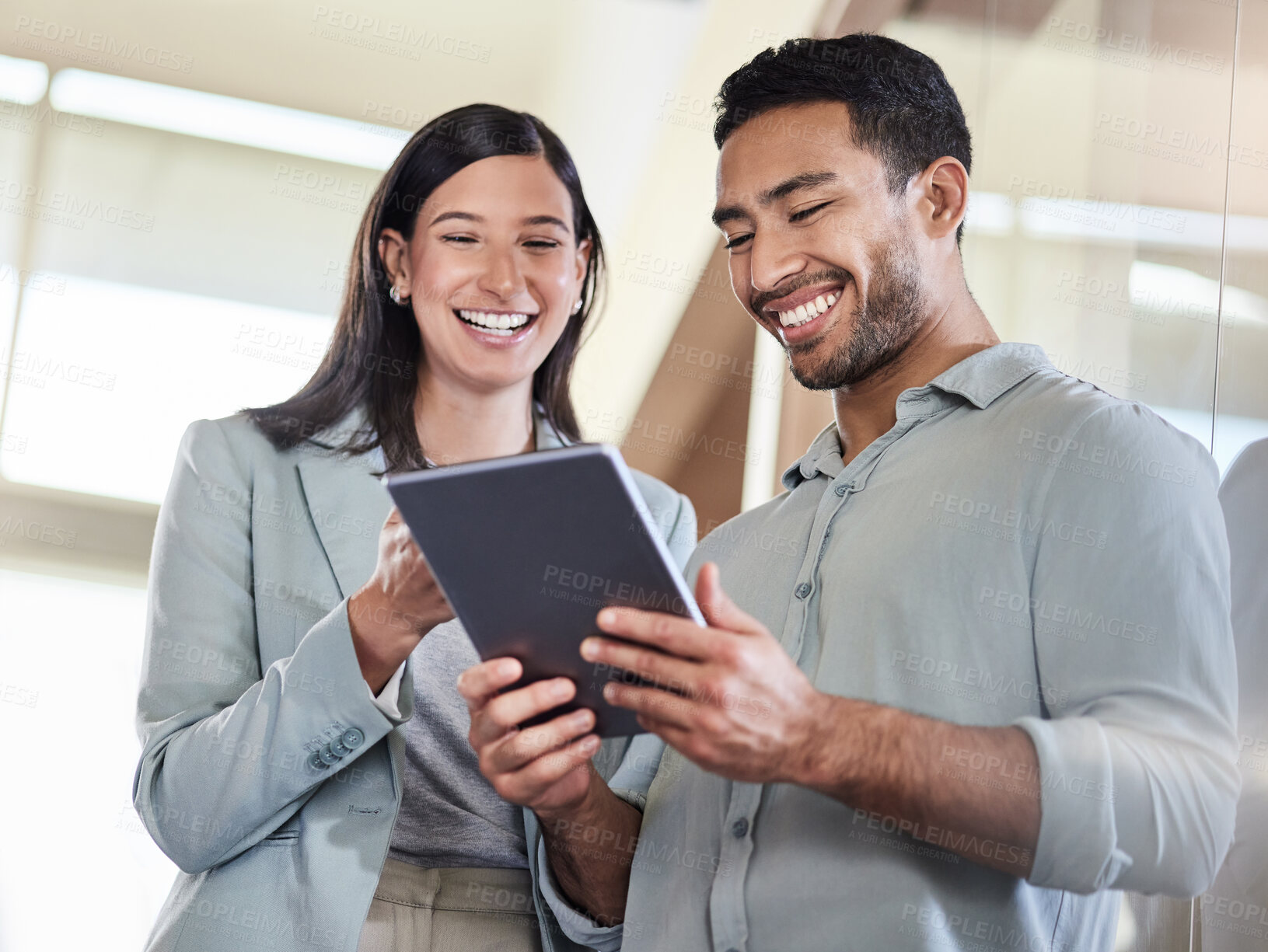 Buy stock photo Shot of two coworkers using a digital tablet together