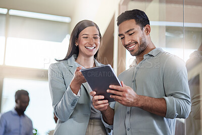 Buy stock photo Shot of two coworkers talking while using a digital tablet