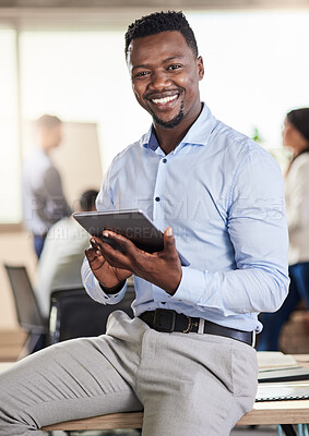 Buy stock photo Shot of a young businessman using his digital tablet at work