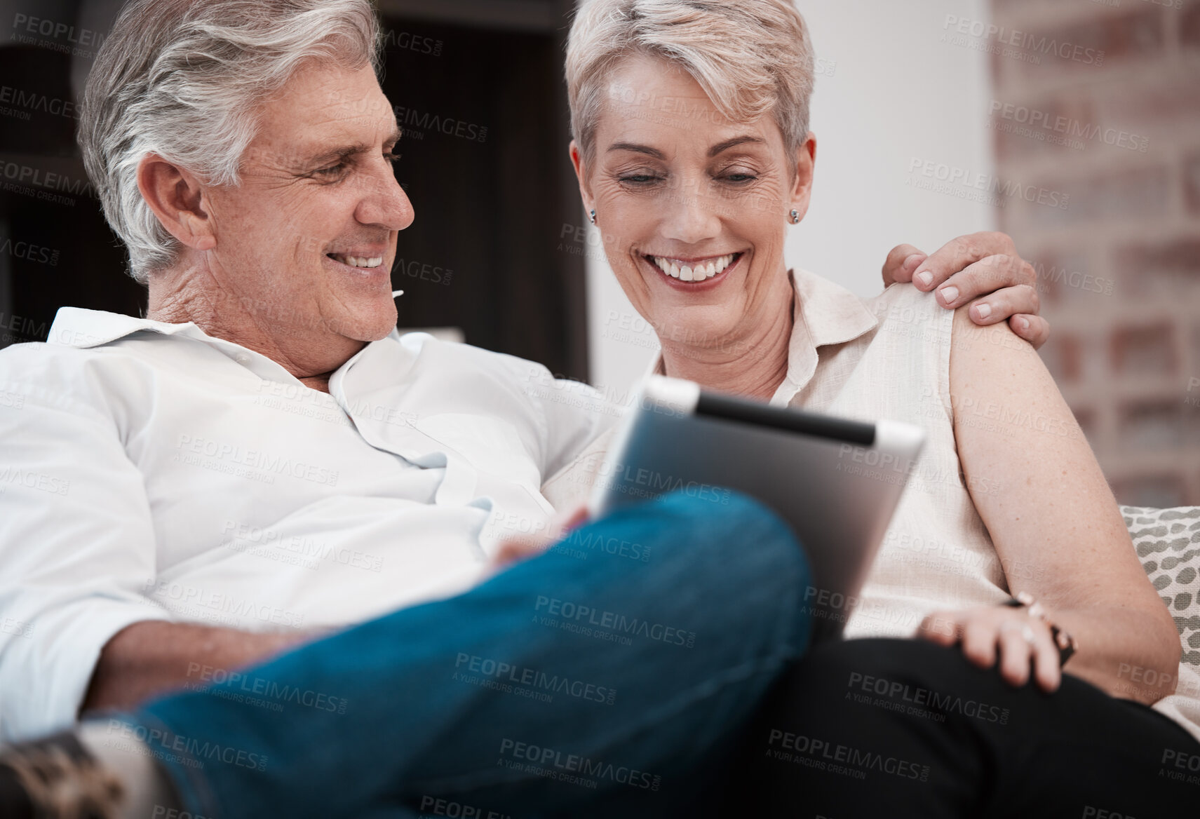 Buy stock photo Happy, tablet and mature couple in home or house for reading on social media for election news. Streaming subscription, hug and man with woman with technology, internet or coffee to relax in Canada