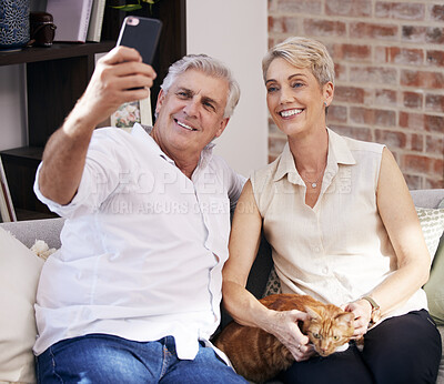 Buy stock photo Senior couple, selfie and smile on sofa in home with cat for fun, living room or apartment for post on social media. Retirement, people and happy for pet, profile picture or video call on smartphone