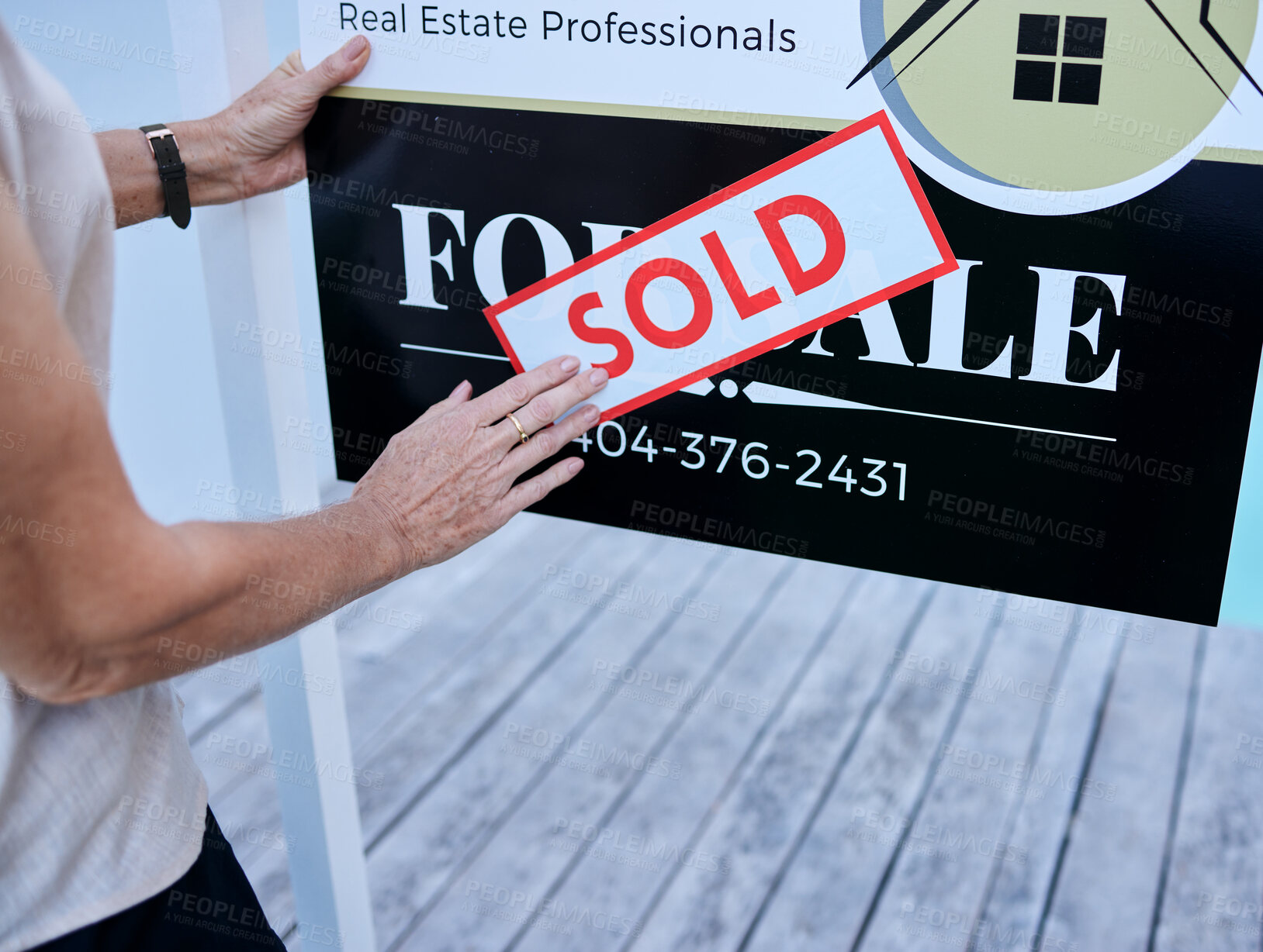 Buy stock photo High angle shot of an unrecognizable female real estate agent sticking a sold sign over a for sale board