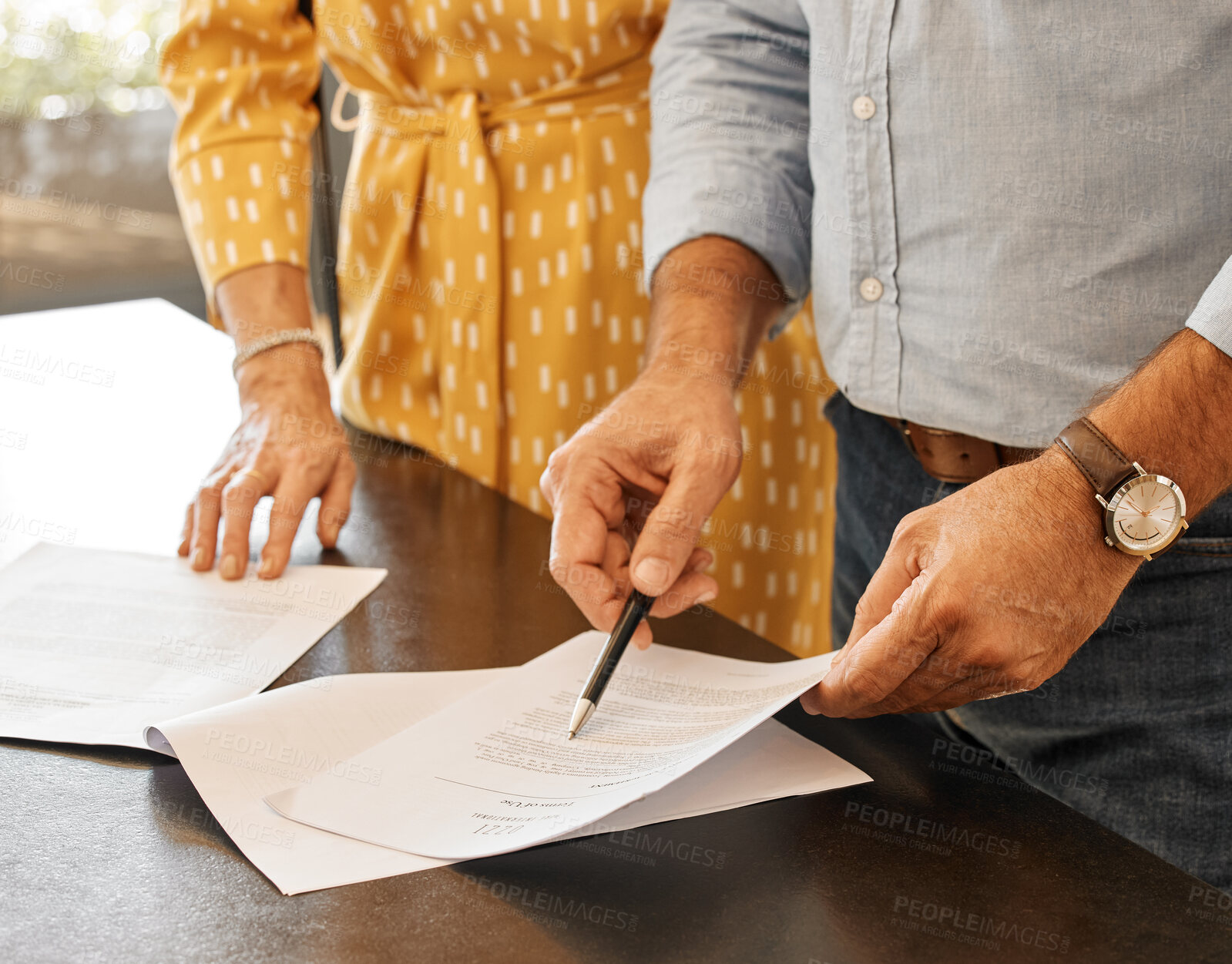 Buy stock photo Shot of two unrecognizable people going through paperwork