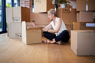 Buy stock photo Shot of a mature woman  unpacking boxes on moving day