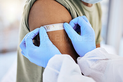 Buy stock photo Cropped shot of an unrecognizable doctor placing a plaster on the injection site of a patient after administering the covid 19 vaccine