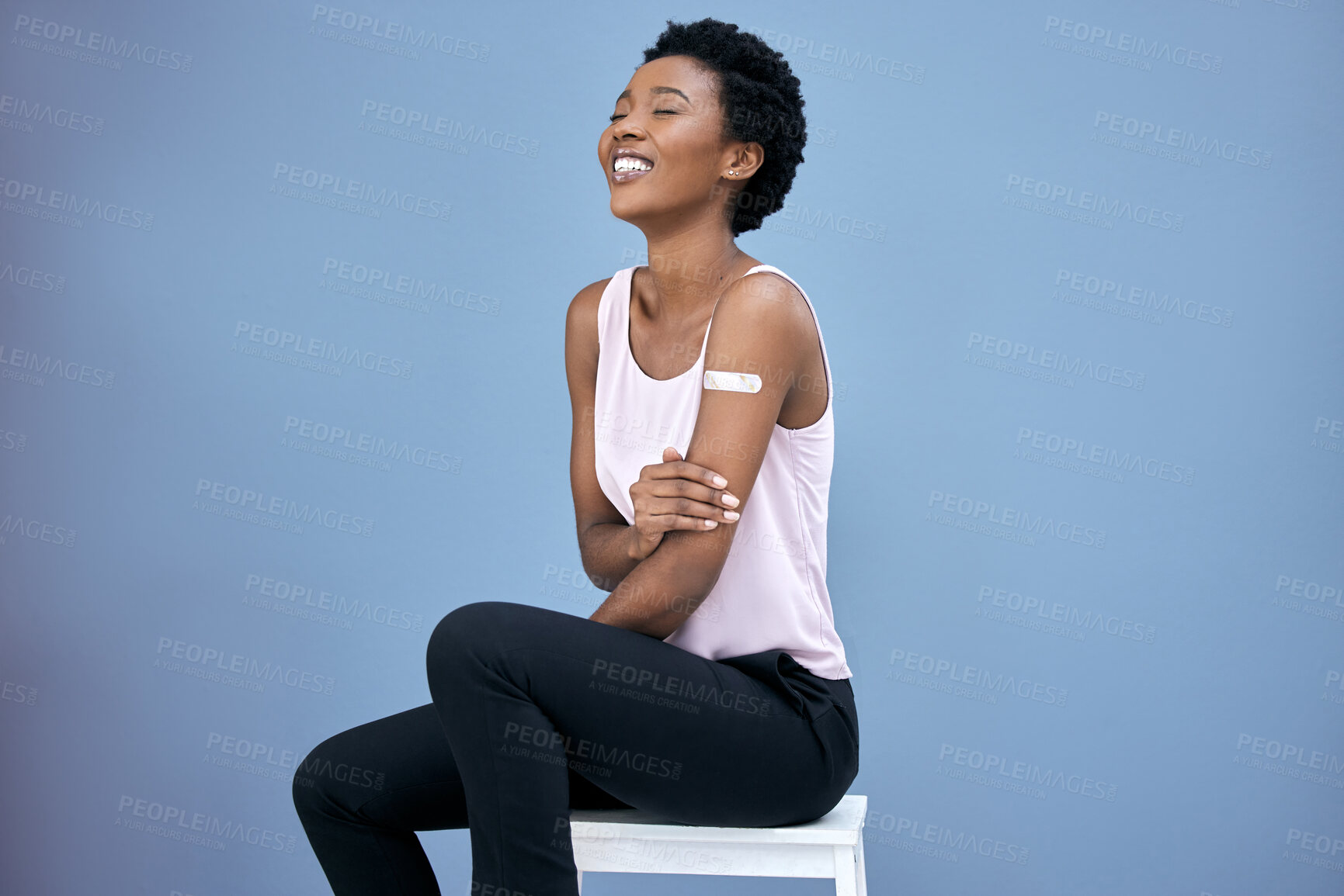 Buy stock photo Shot of an attractive young woman sitting alone in the studio after getting her Covid vaccine