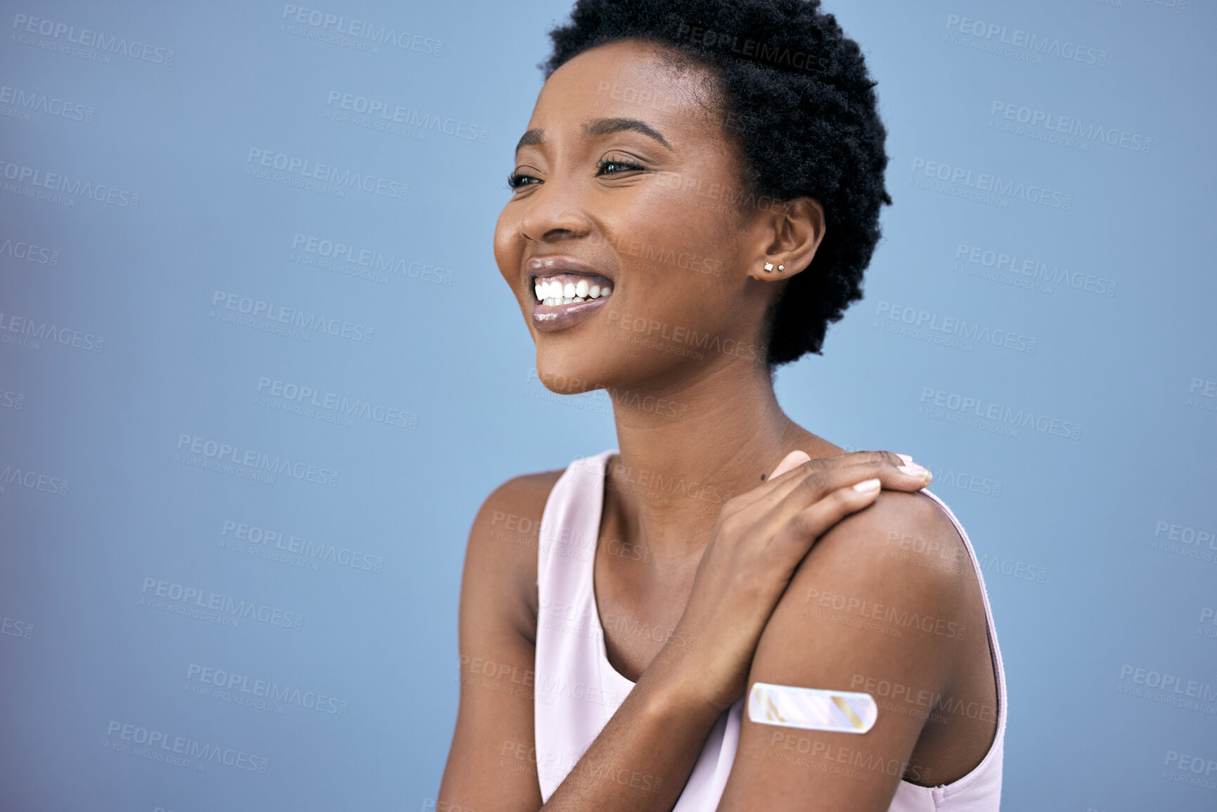 Buy stock photo Black woman, proud and vaccine plaster in studio for prevention, happy and booster shot on blue background. Medication, smile and female person with pride for promote wellness, healthcare or medicine