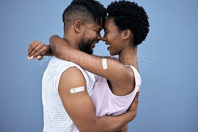 Buy stock photo Vaccination, hug and black couple with plaster on arm in studio for cure, healthcare or booster shot on blue background. Smile, love and man with woman for medical injection, immunity or plaster