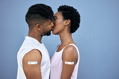 Buy stock photo Shot of a young couple kissing each other in the studio after getting their Covid vaccines