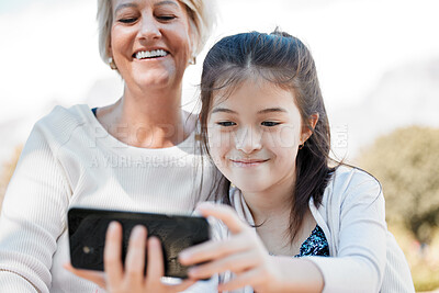 Buy stock photo Senior woman, child and selfie in park with phone for social media update, profile picture and memory together. Mobile, grandma and young girl in nature for online digital gallery and photography