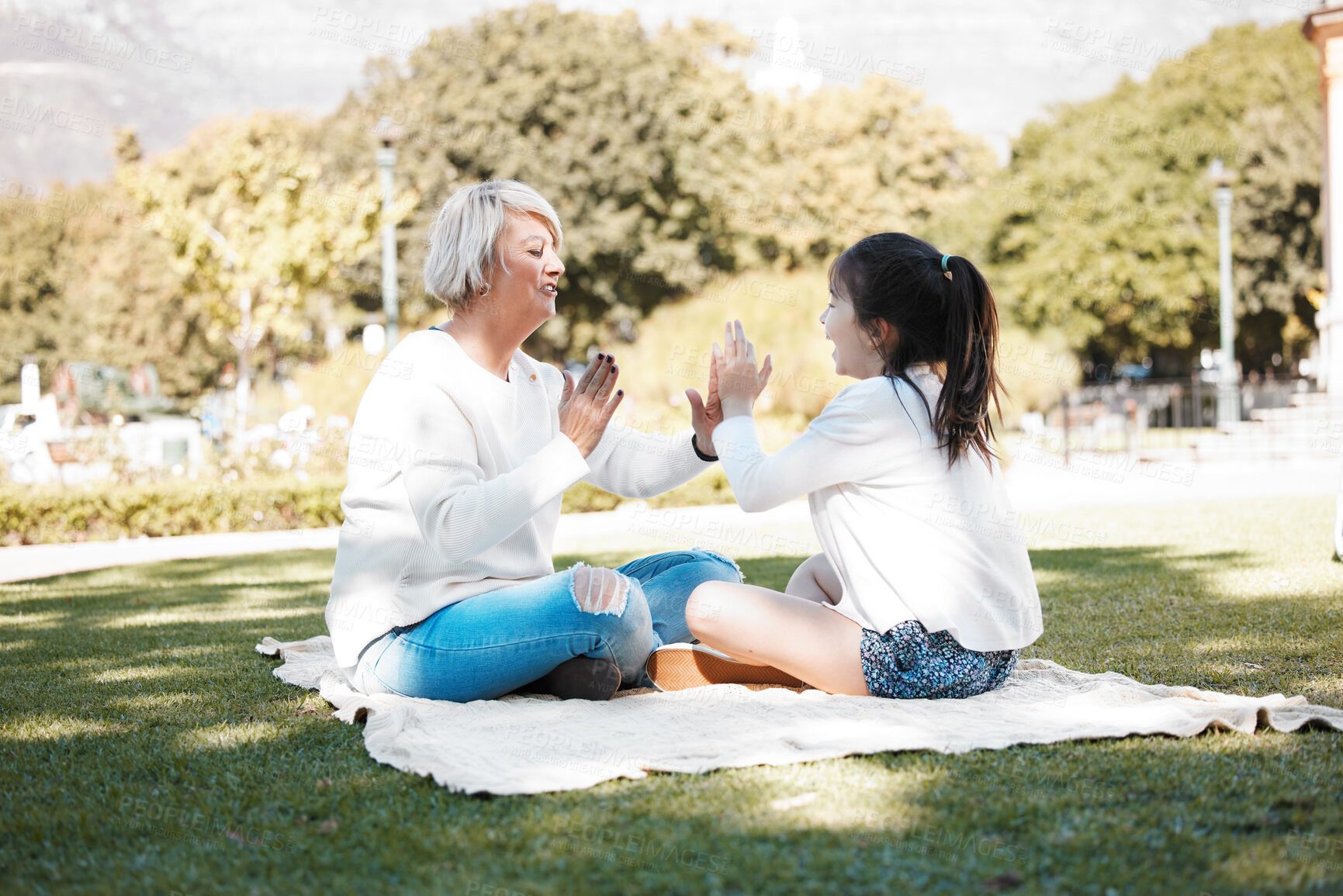 Buy stock photo Shot of a little girl having fun with her grandmother outdoors