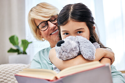 Buy stock photo Smile, book and senior woman with child reading for knowledge with teddy bear at home together. Happy, bonding and elderly grandmother relaxing and enjoying story with girl kid holding toy at house.