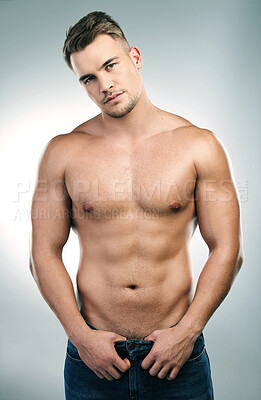 Buy stock photo Studio shot of a handsome young man posing shirtless against a grey background