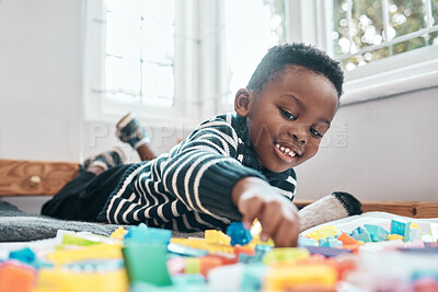 Buy stock photo Shot of an adorable little boy playing with building blocks at home