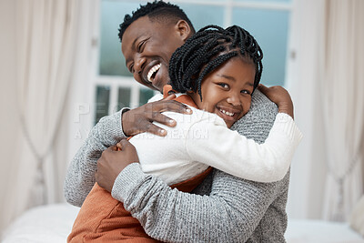 Buy stock photo Shot of a young father hugging his daughter while bonding at home