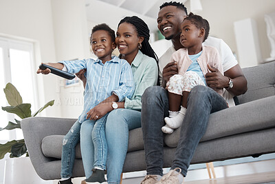 Buy stock photo Low angle shot of an affectionate young family of four watching TV in the living room at home