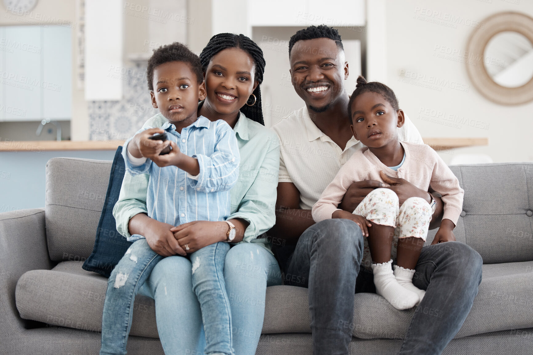 Buy stock photo Cropped portrait of an affectionate young family of four watching TV in the living room at home
