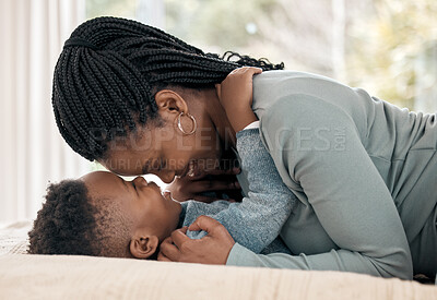 Buy stock photo Cropped shot of an adorable little boy sharing a tender moment with his mother on a bed at home