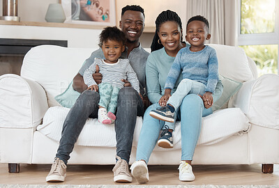 Buy stock photo Full length shot of a young couple sitting in the living room at home and bonding with their children