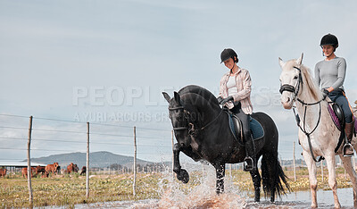Buy stock photo Full length shot of two attractive young women riding horses outdoors on a ranch