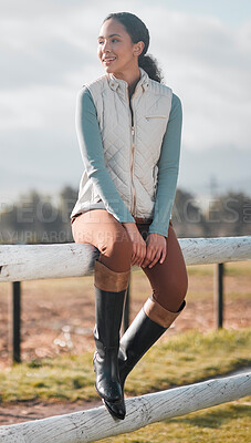 Buy stock photo Full length shot of an attractive young woman sitting alone on a wooden fence on a farm