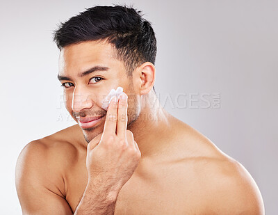 Buy stock photo Face, portrait and man with lotion in studio background for skin hydration, anti aging and collagen. Moisturizer, male model and skincare with cosmetics for smooth, glowing or soft texture with pride