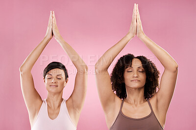 Buy stock photo Cropped shot of two attractive young female athletes meditating in studio against a pink background