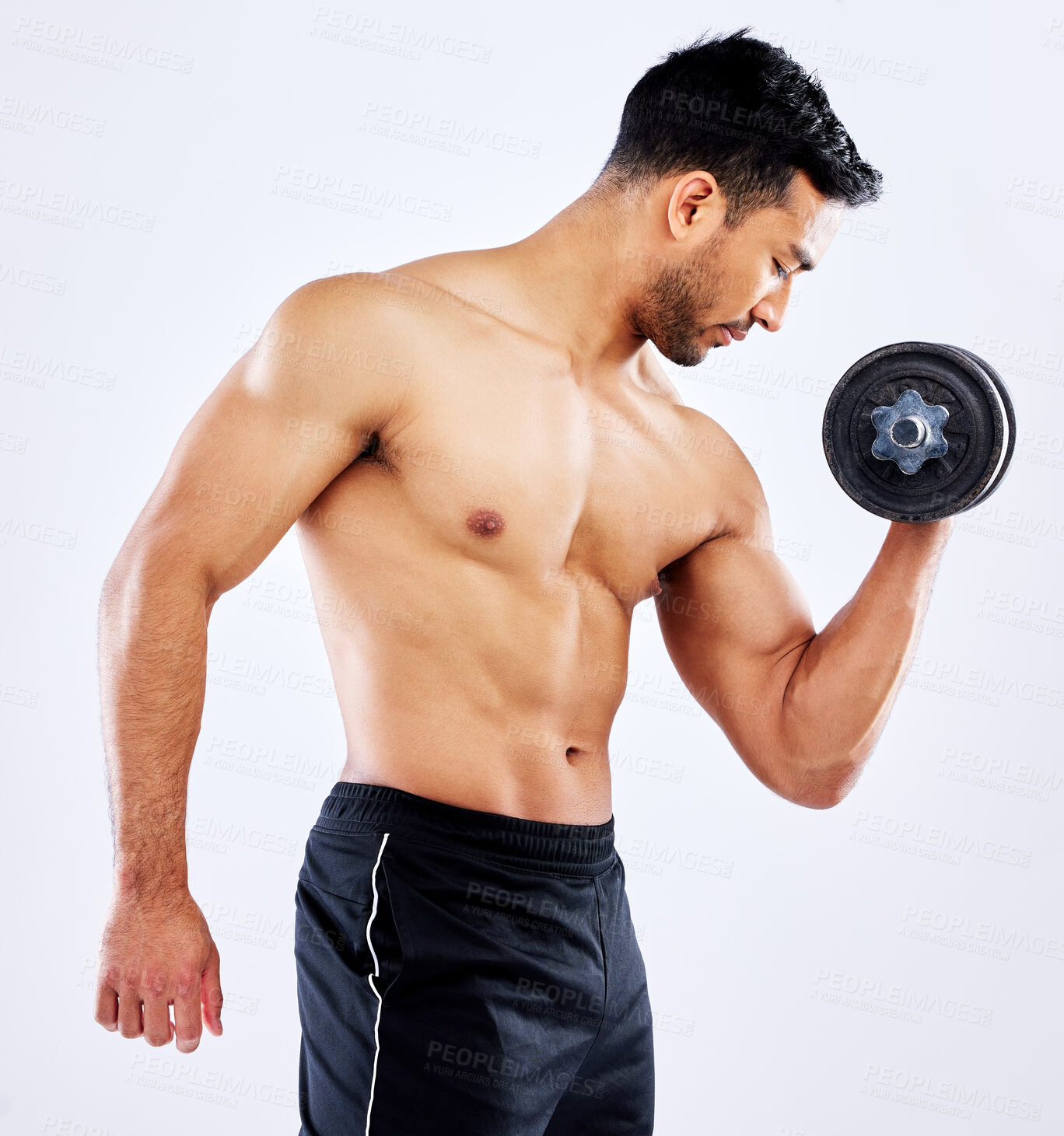 Buy stock photo Shot of a young man flexing his bicep muscles while holding a weight against a studio background